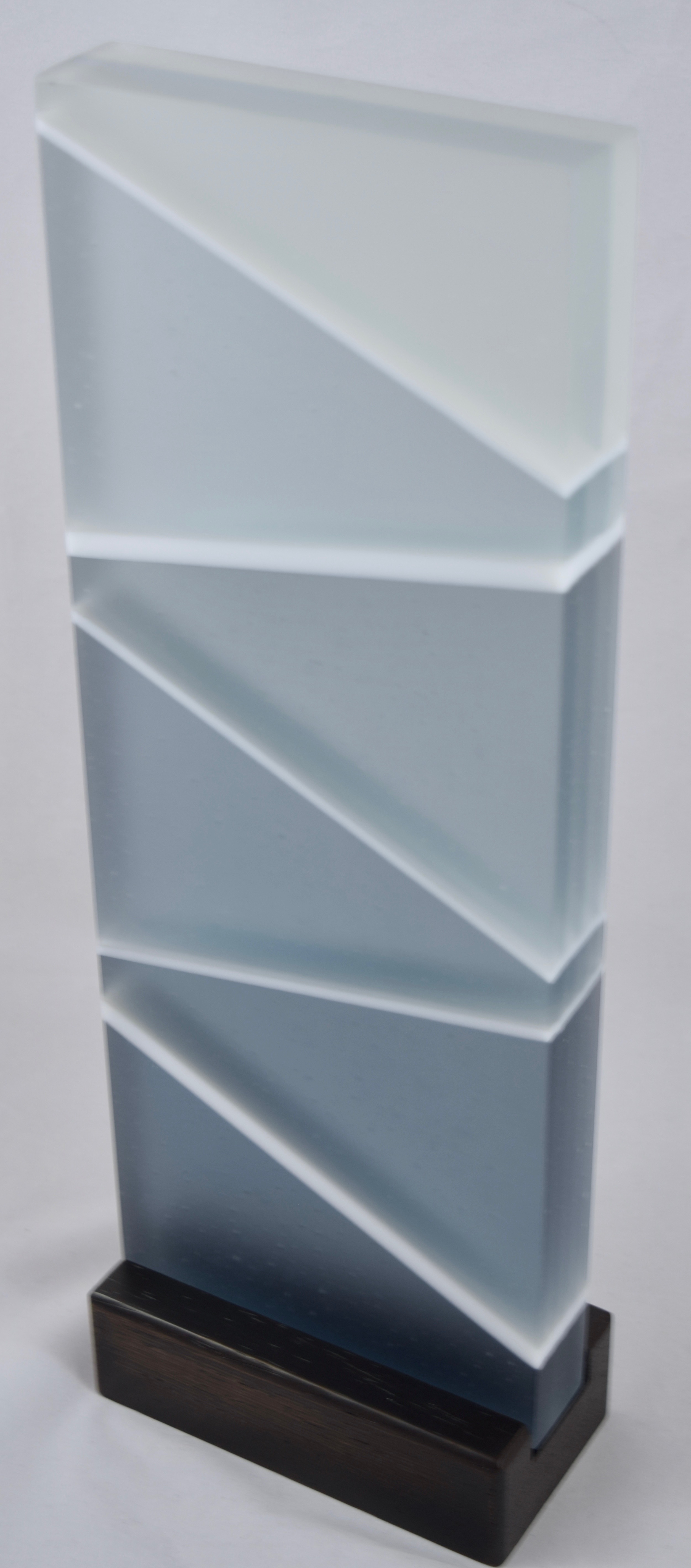 It Is Well - Kiln-formed contemporary glass sculpture created from blue, clear and white glass. Hand-sanded to a translucent finish. Glass with wood stand measures 5.25"w x 15"h x 2.75"d. Sold.