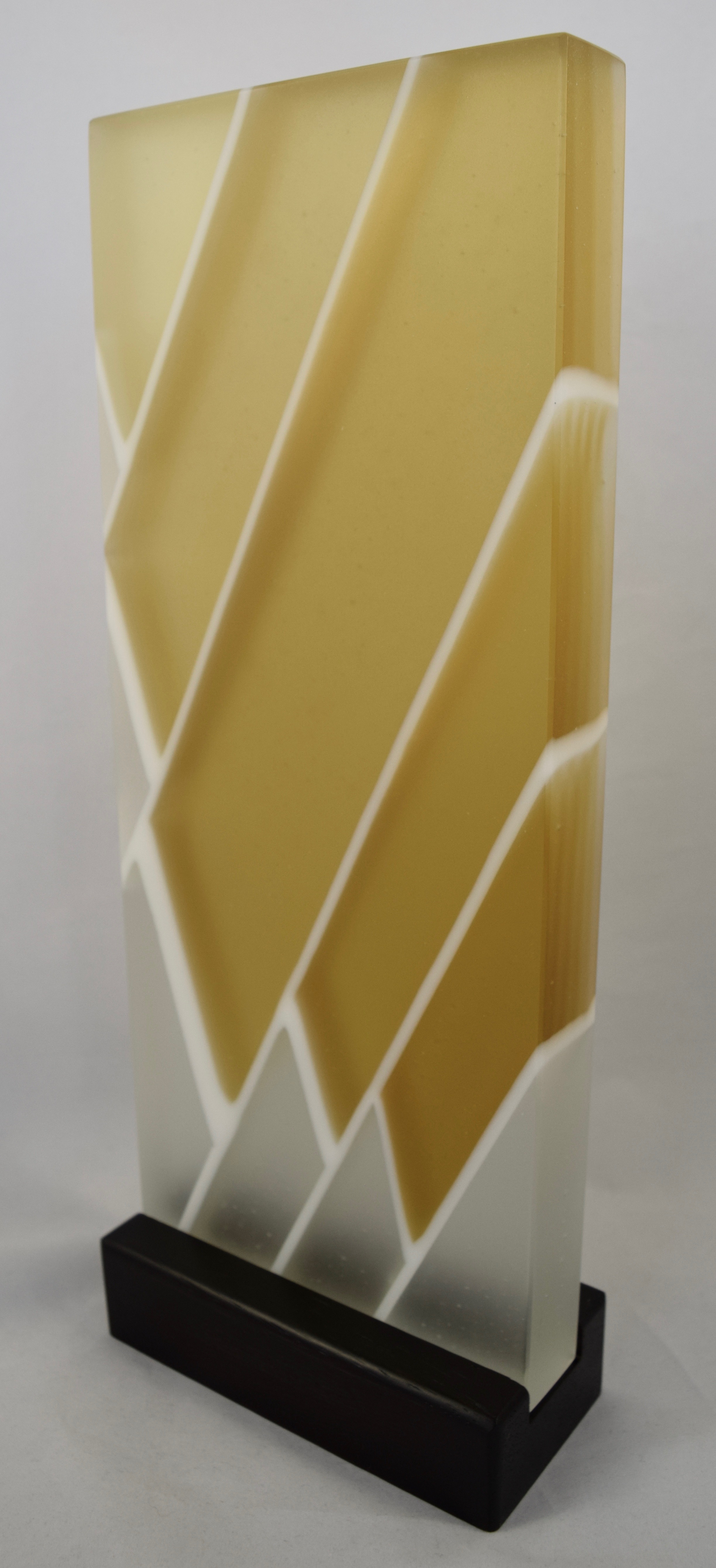 Quiet Strength - Kiln-formed glass sculpture created from amber, clear and white glass. Hand-sanded to a translucent finish. Glass with wood stand measures 5.875"w x 15.125"h x 2.75"d. Sculpture is available for sale.