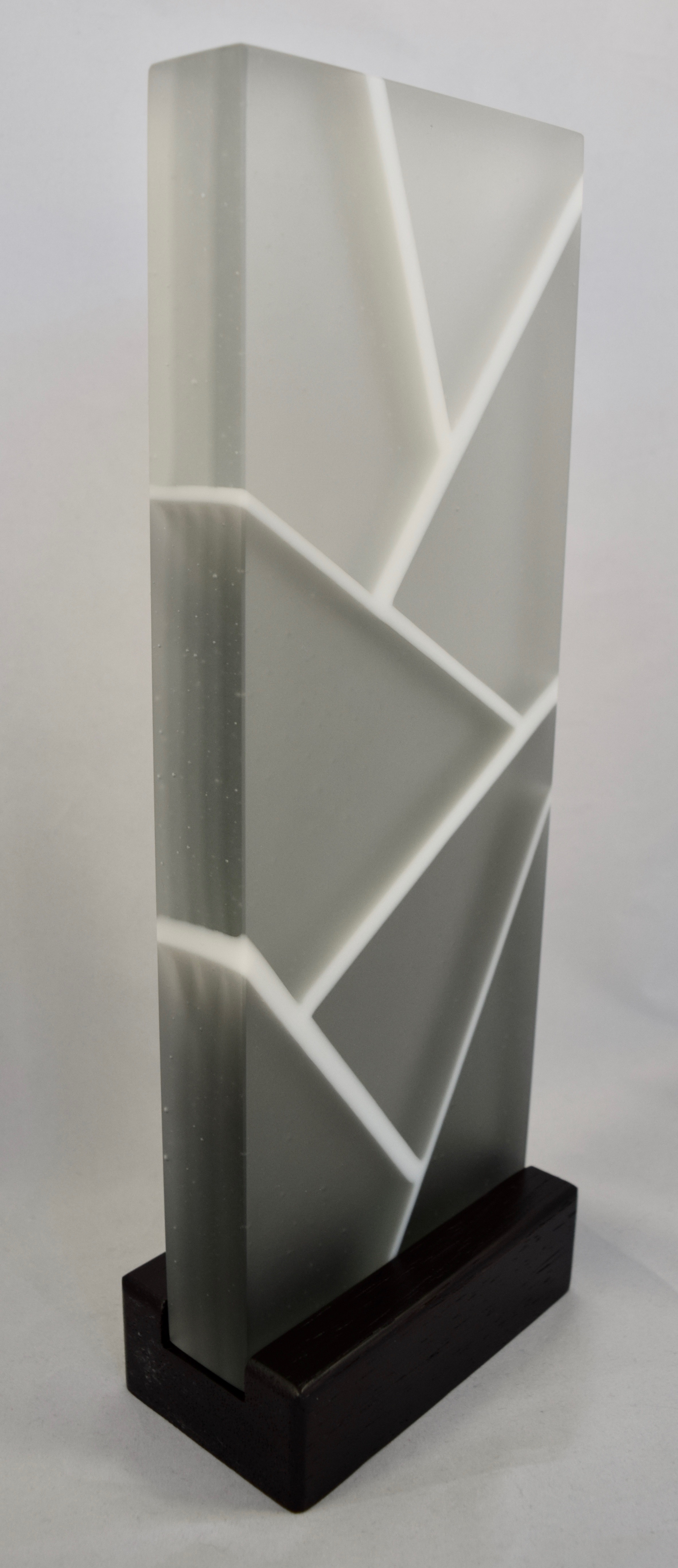 Gaining Clarity - Kiln-formed glass sculpture created from various shades of grey and white glass. Hand-sanded to a translucent finish. Glass with wood stand measures 5"w x 13.25"h x 2.75"d. Sculpture is available for sale through Chasen Galleries in Sarasota, Florida.
